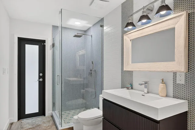 a bathroom with a sink a toilet and shower