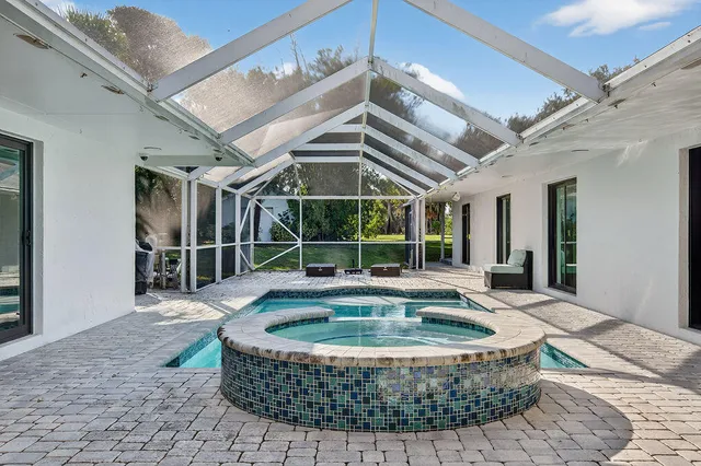a view of a patio with couches chairs and wooden floor
