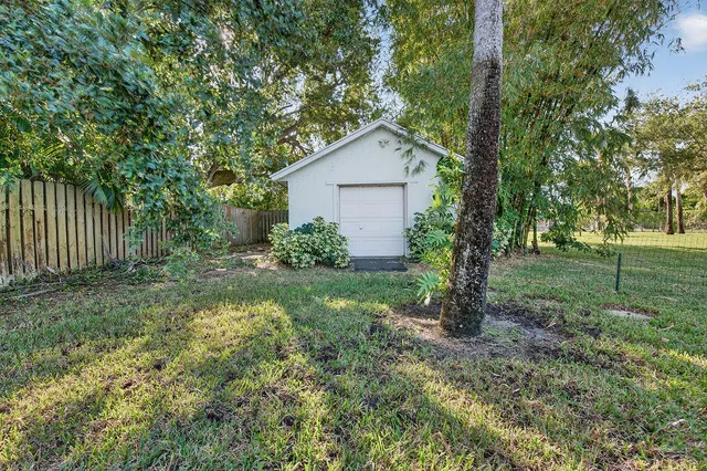a view of a yard with wooden fence and a large tree
