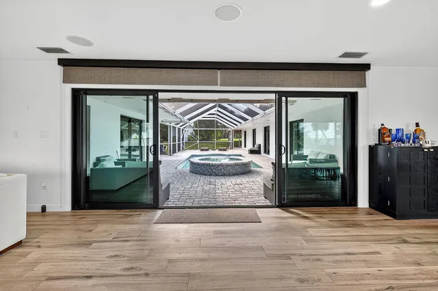 a kitchen with stainless steel appliances a dining table chairs and wooden floor