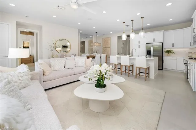 a living room with lots of white furniture and a table