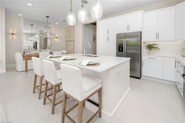 a kitchen that has a lot of cabinets a sink and wooden floor