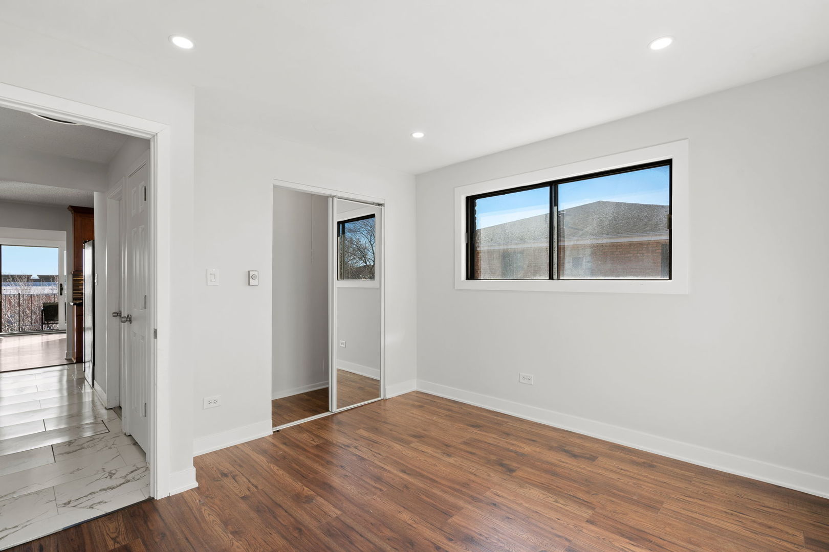7242 West 86th Street, Unit 3A Bridgeview, IL 60455 - Photo 11 of 14 a view of an empty room with wooden floor and a window