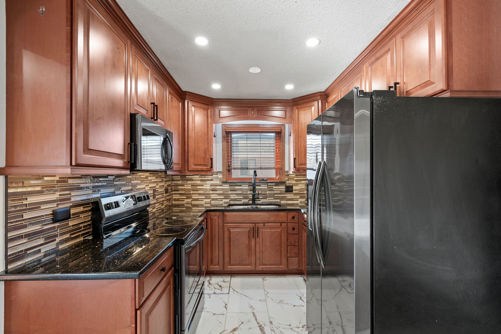 7242 West 86th Street, Unit 3A Bridgeview, IL 60455 - Photo 8 of 14 a kitchen with granite countertop stainless steel appliances and wooden cabinets