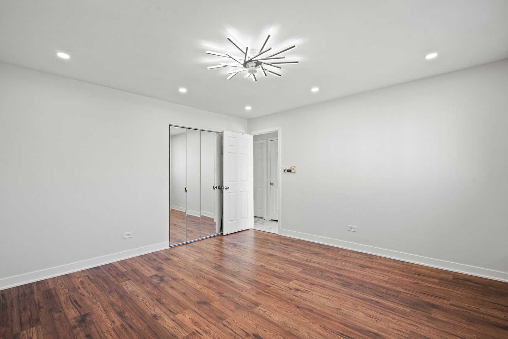 7242 West 86th Street, Unit 3A Bridgeview, IL 60455 - Photo 9 of 14 a view of an empty room with wooden floor and a ceiling fan
