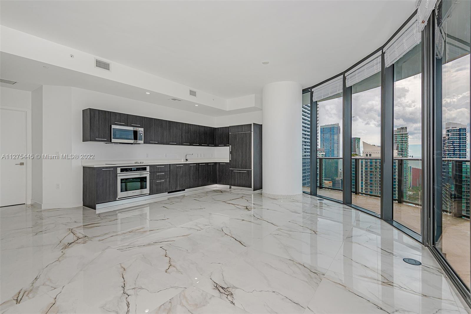 45 Southwest 9th Street, Unit 4206 Miami, FL 33130 - Photo 4 of 19 a view of an empty room with a fireplace and windows