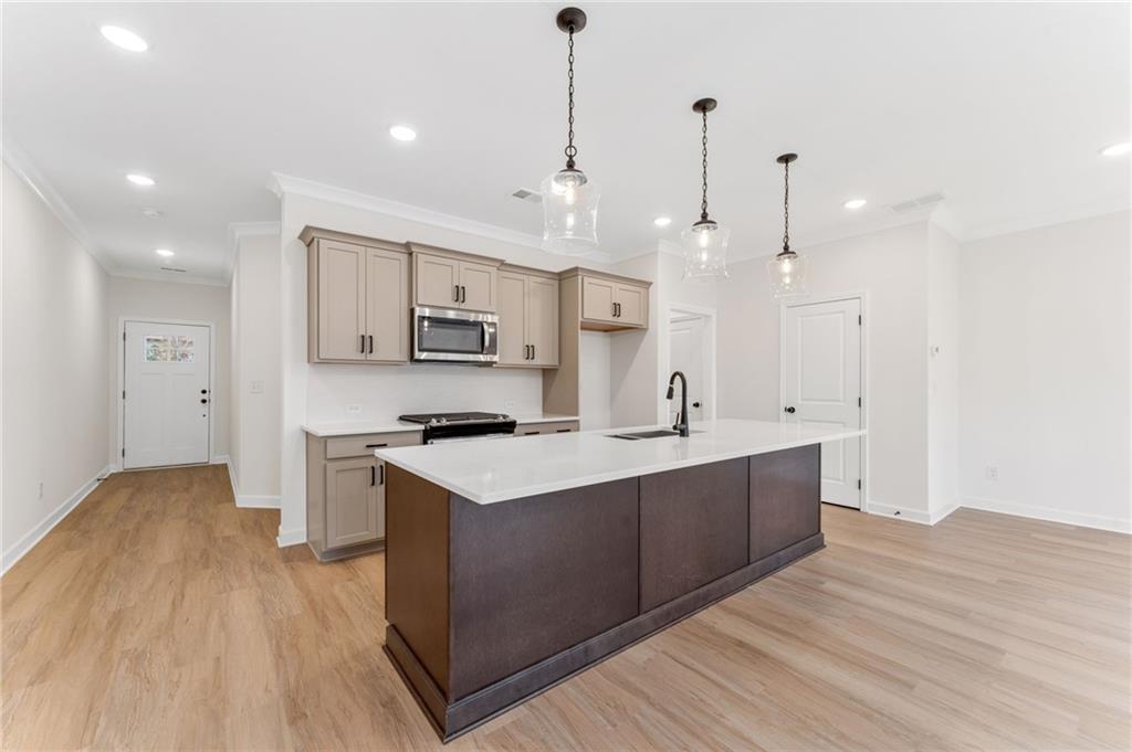 340 Colsen Drive Acworth, GA 30102 - Photo 11 of 25 a large kitchen with stainless steel appliances kitchen island a large island in the center and wooden floors