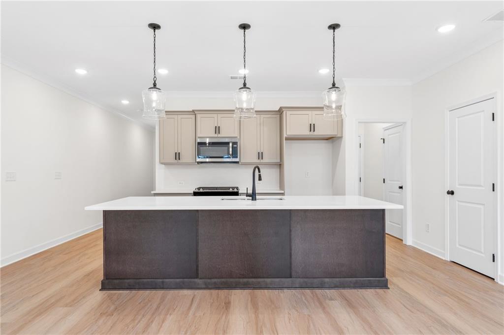 340 Colsen Drive Acworth, GA 30102 - Photo 16 of 25 a large kitchen with stainless steel appliances a large counter top a sink and a wooden floor