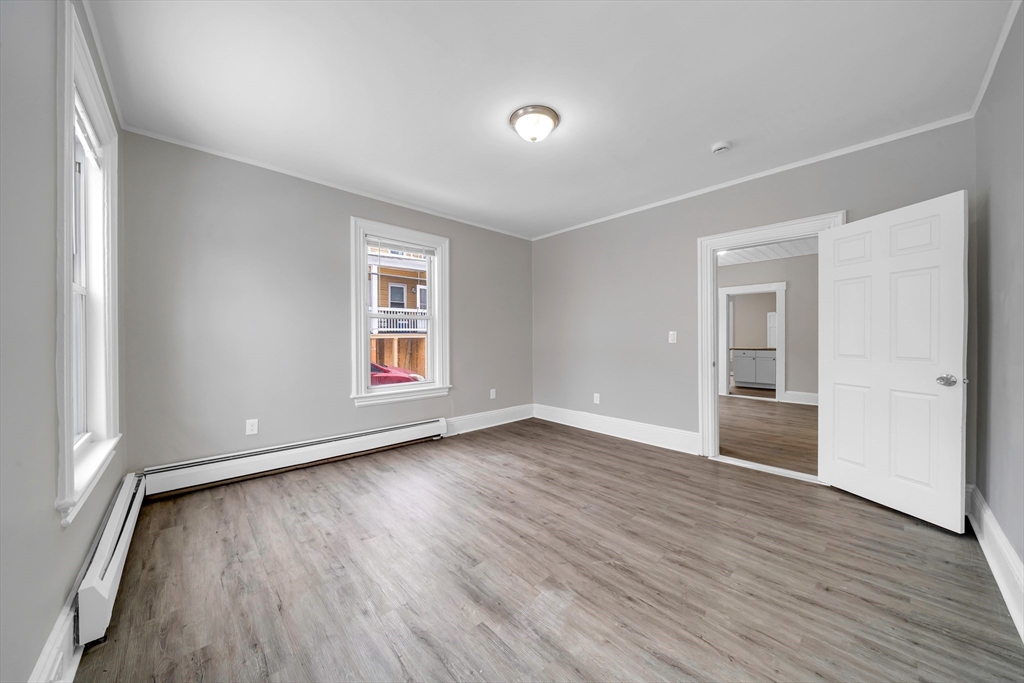 49 6th Street Lowell, MA 01850 - Photo 11 of 37 a view of an empty room with wooden floor and a window