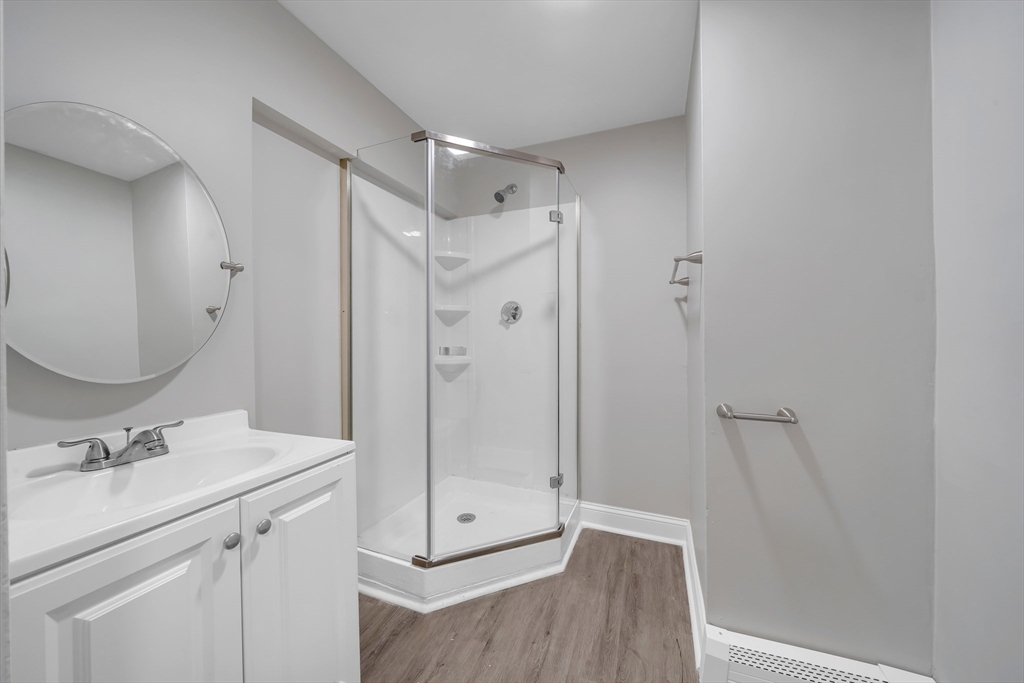 49 6th Street Lowell, MA 01850 - Photo 14 of 37 a bathroom with a shower sink and mirror