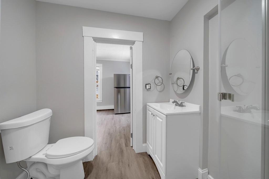 49 6th Street Lowell, MA 01850 - Photo 15 of 37 a bathroom with a toilet sink and mirror