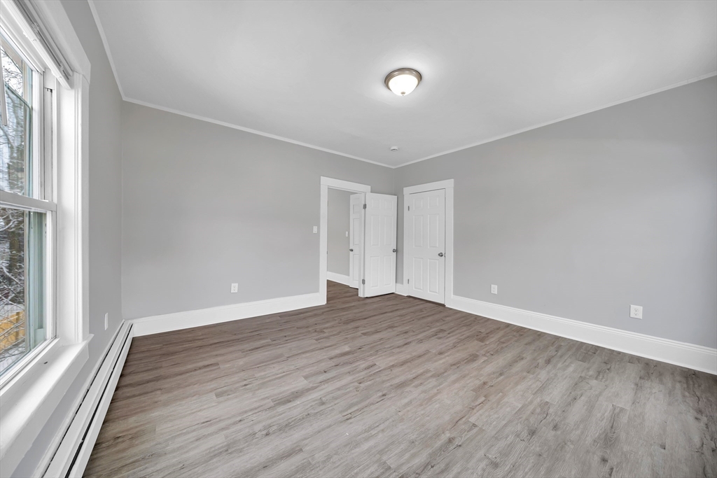 49 6th Street Lowell, MA 01850 - Photo 22 of 37 a view of an empty room with wooden floor and a window