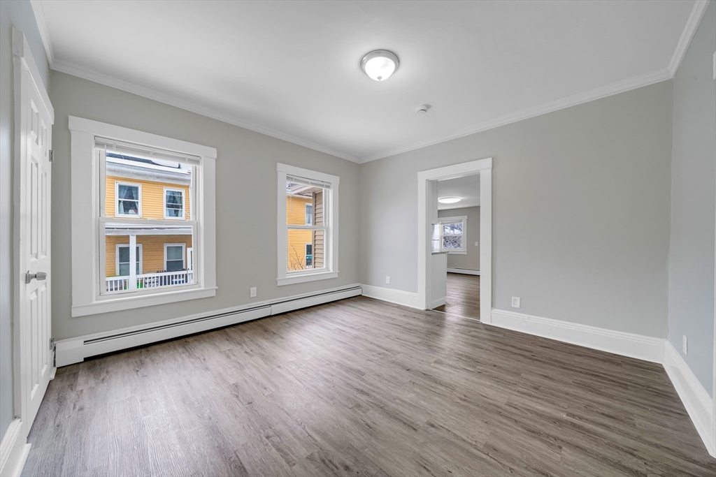 49 6th Street Lowell, MA 01850 - Photo 24 of 37 a view of an empty room with wooden floor and a window
