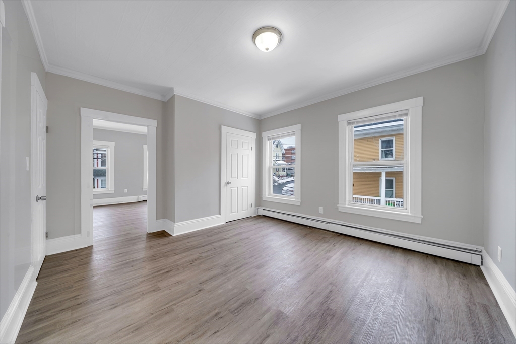 49 6th Street Lowell, MA 01850 - Photo 25 of 37 an empty room with wooden floor and windows