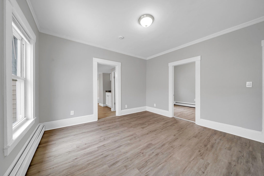 49 6th Street Lowell, MA 01850 - Photo 26 of 37 a view of an empty room with wooden floor and a window