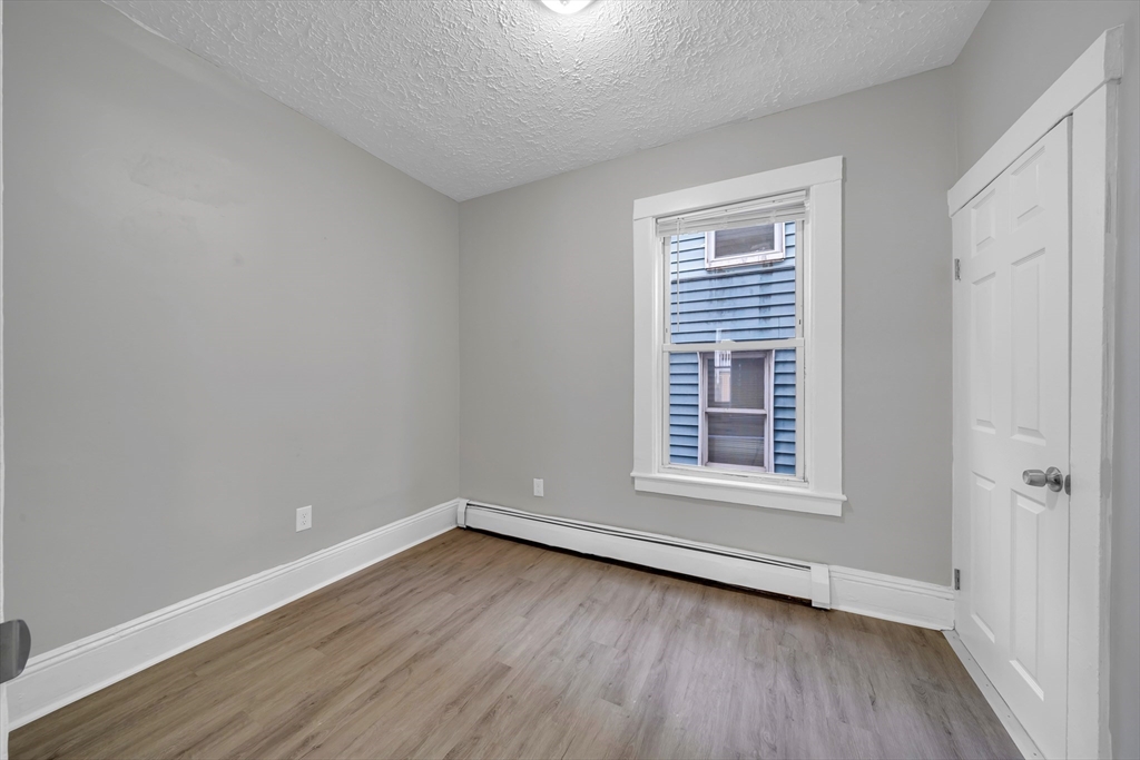 49 6th Street Lowell, MA 01850 - Photo 8 of 37 a view of a room that has wooden floor and windows in it