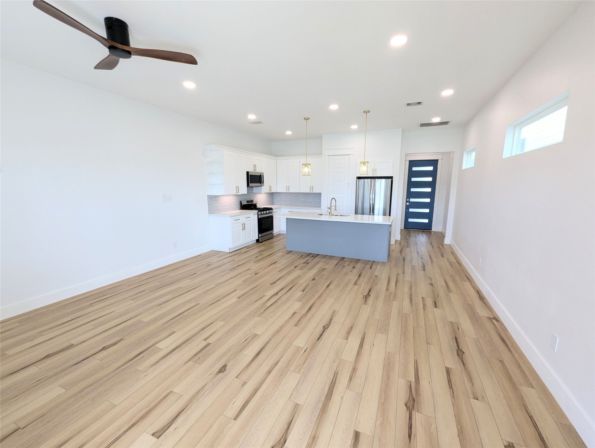 4913 Fisk Street Houston, TX 77009 - Photo 10 of 27 a view of kitchen and empty room with wooden floor