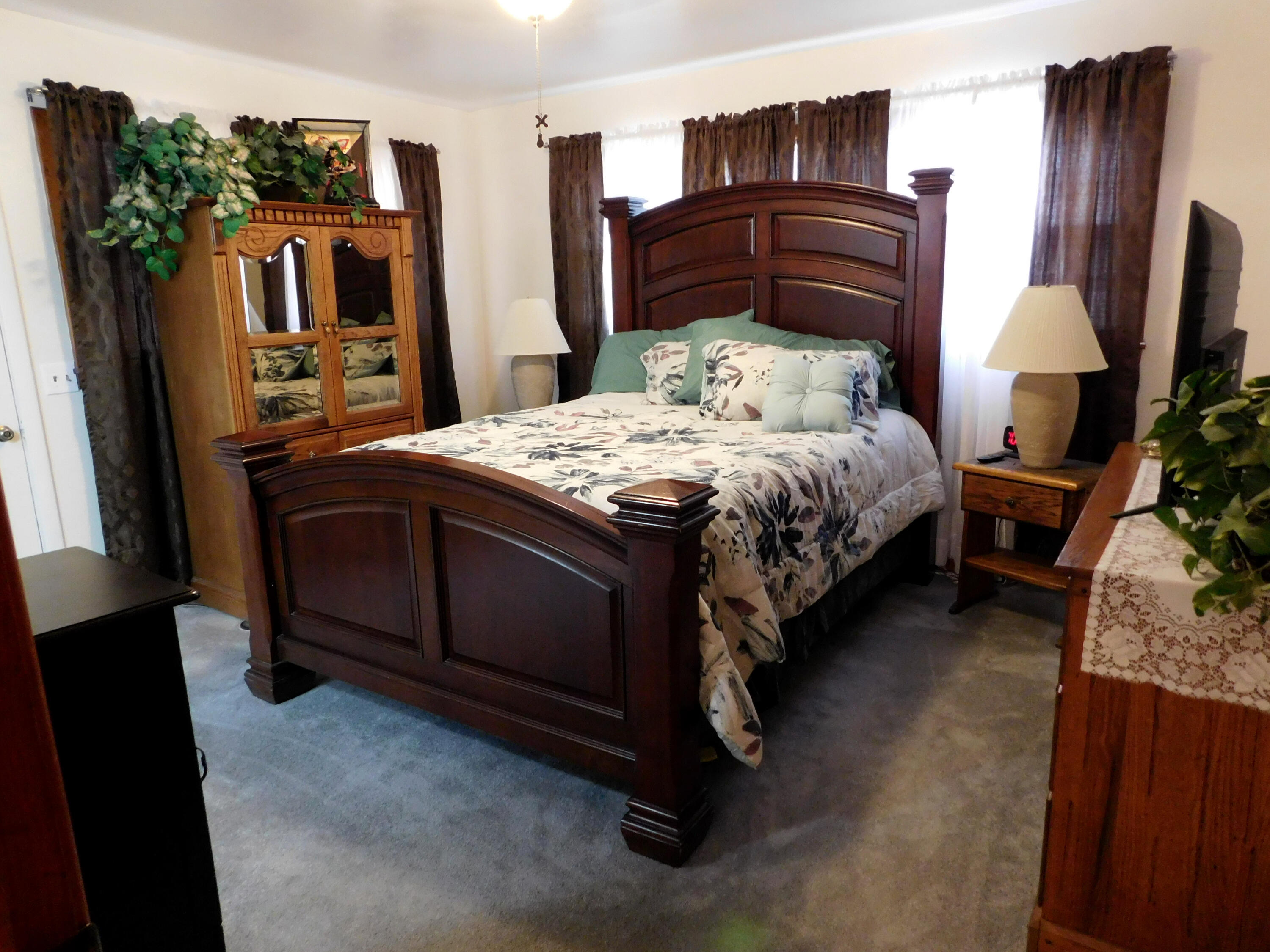 122 West 16th Street Muleshoe, TX 79347 - Photo 18 of 27 a bedroom with a bed dresser and a flat tv screen