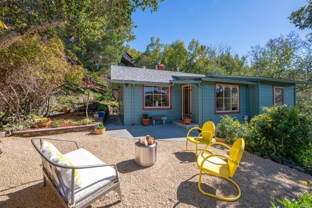 a view of a house with backyard and sitting area