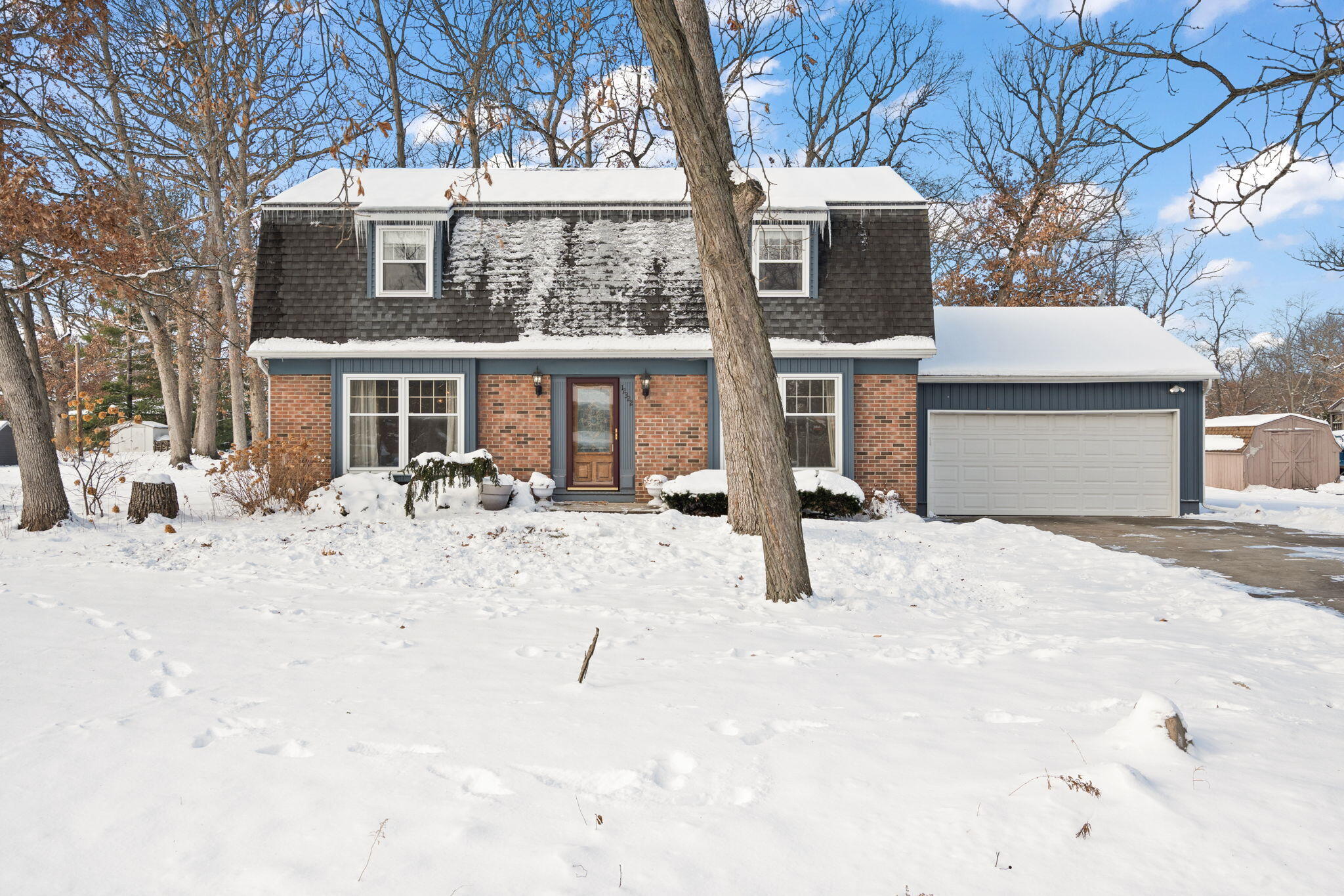 a front view of a house with a yard covered with snow