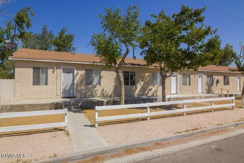 2618 Desert Street, Unit 11 Rosamond, CA 93560 - Photo 2 of 8 a view of a white house with a large tree and plants