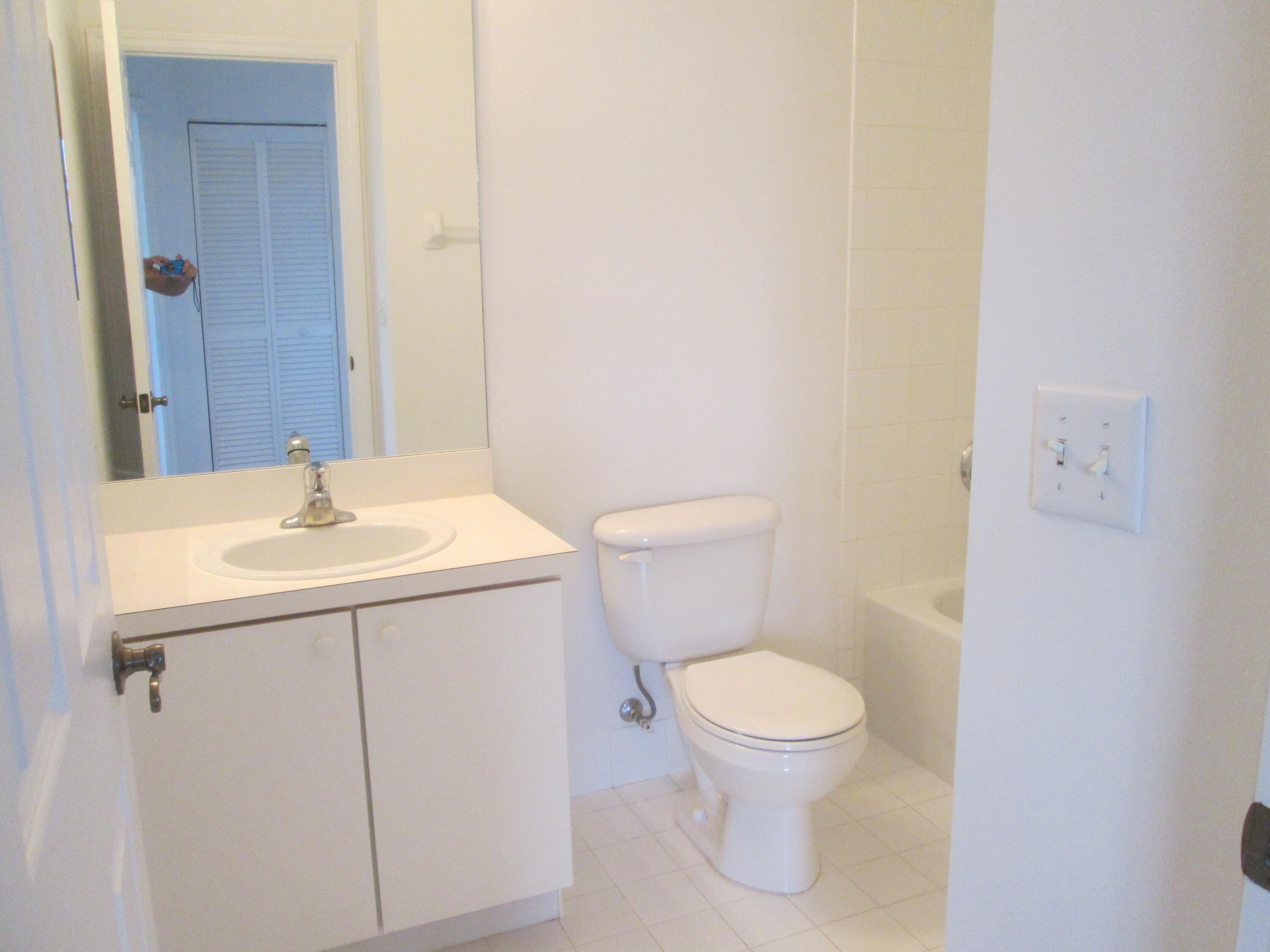 105 Lighthouse Circle, Unit J Tequesta, FL 33469 - Photo 15 of 18 a bathroom with a sink a toilet and a mirror