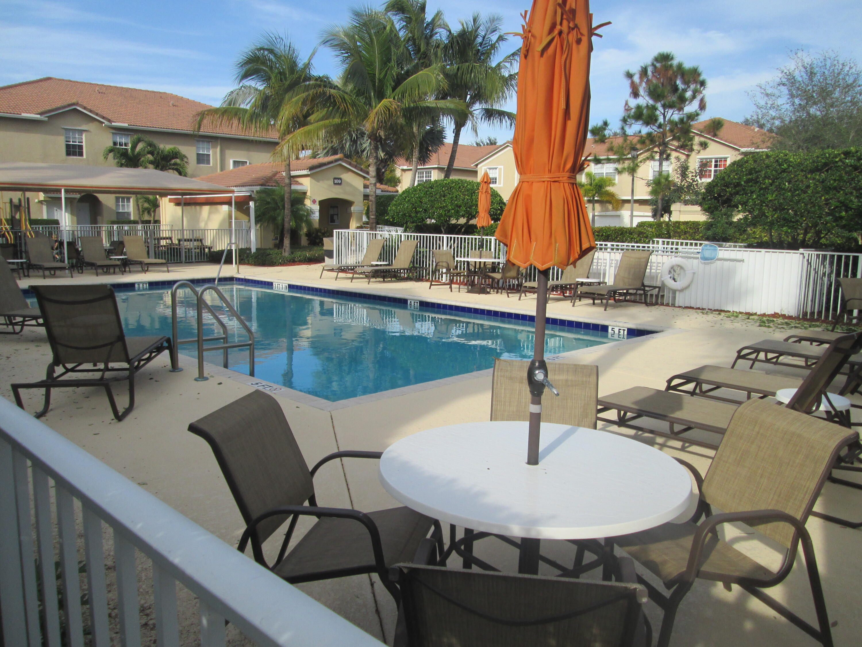 105 Lighthouse Circle, Unit J Tequesta, FL 33469 - Photo 18 of 18 a view of a patio with a table and chairs