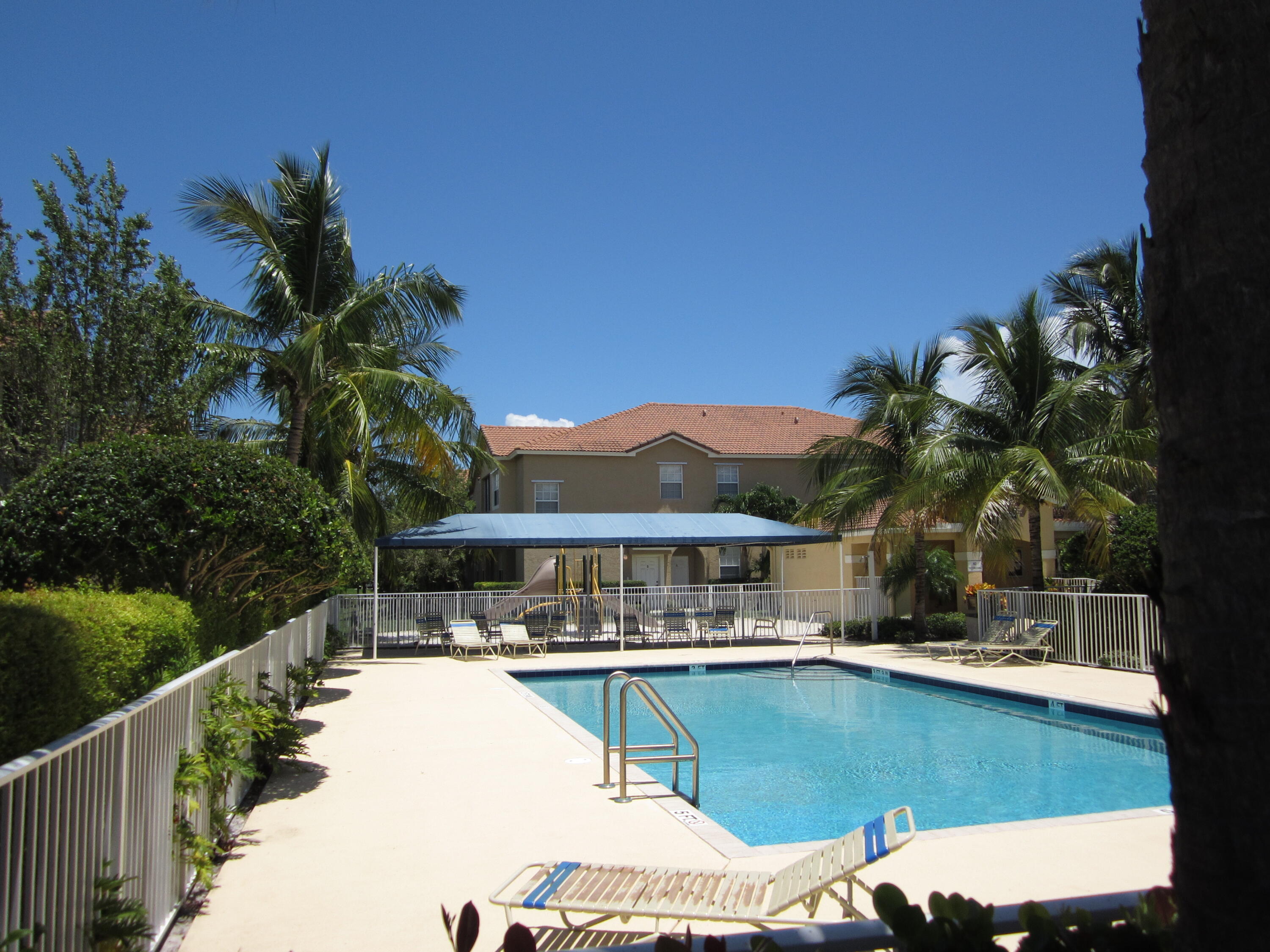 105 Lighthouse Circle, Unit J Tequesta, FL 33469 - Photo 3 of 18 a view of swimming pool with outdoor seating and plants