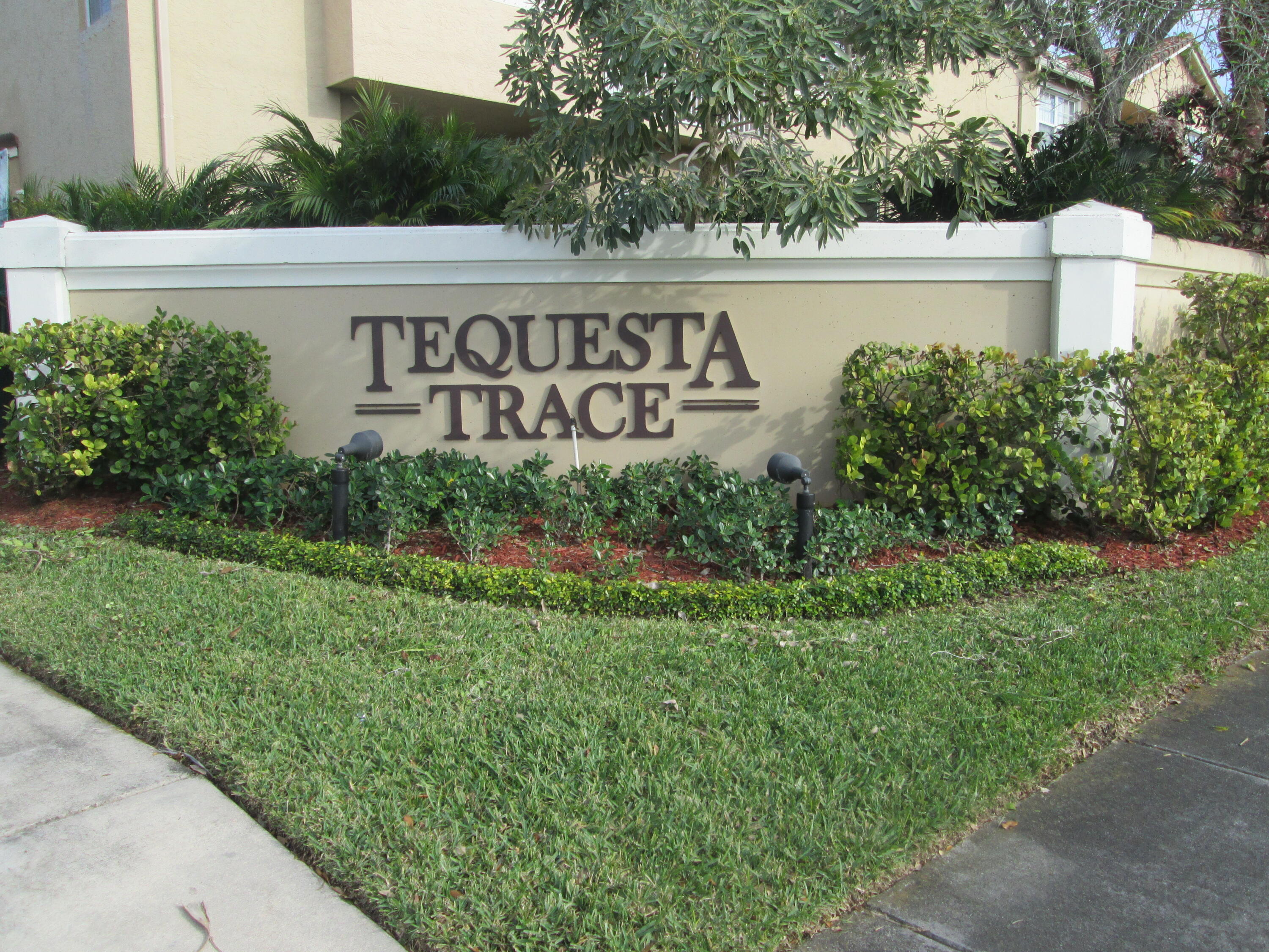 105 Lighthouse Circle, Unit J Tequesta, FL 33469 - Photo 4 of 18 a view of sign board with yard and trees around