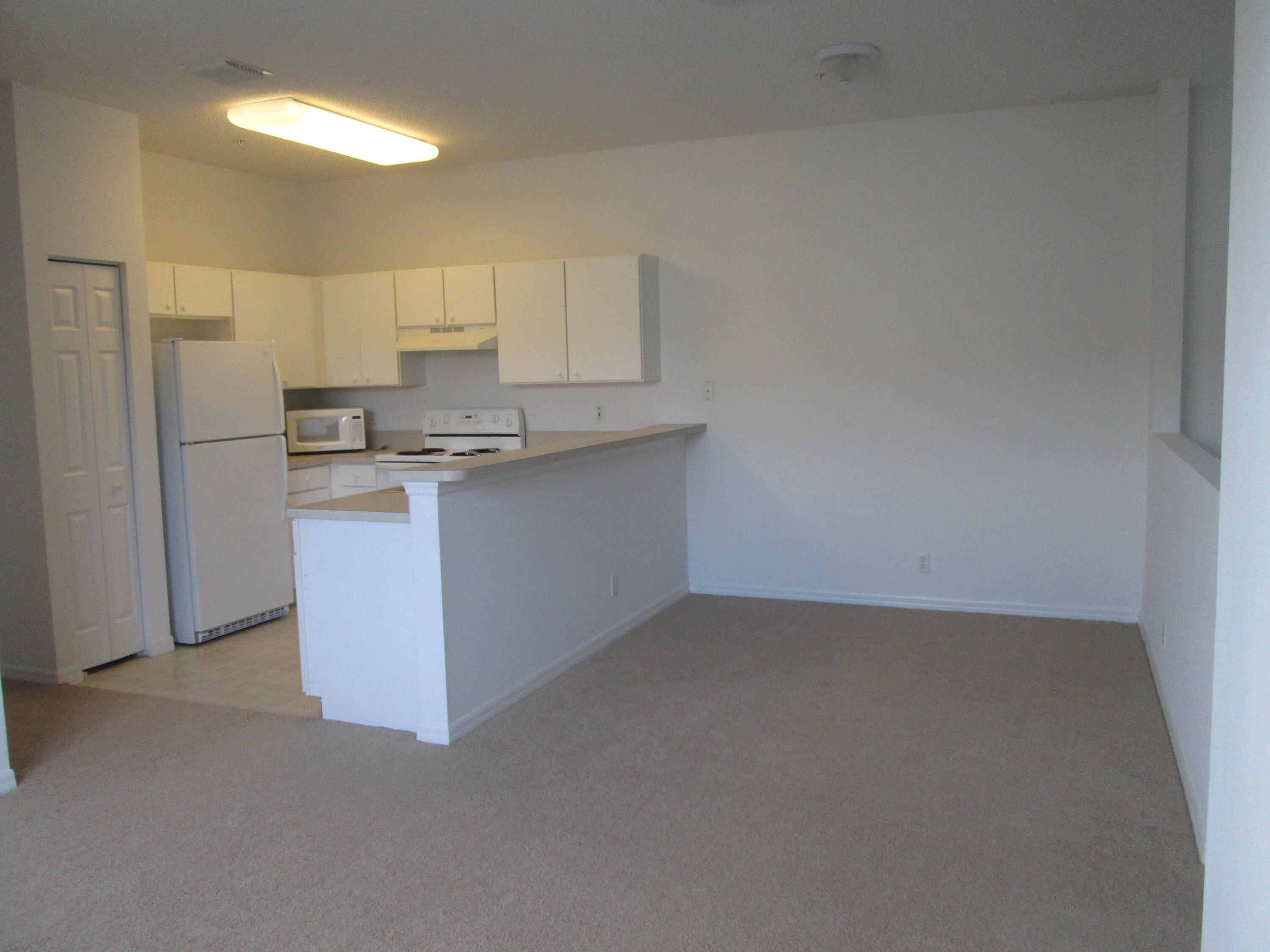 105 Lighthouse Circle, Unit J Tequesta, FL 33469 - Photo 7 of 18 a kitchen with stainless steel appliances a sink stove and refrigerator