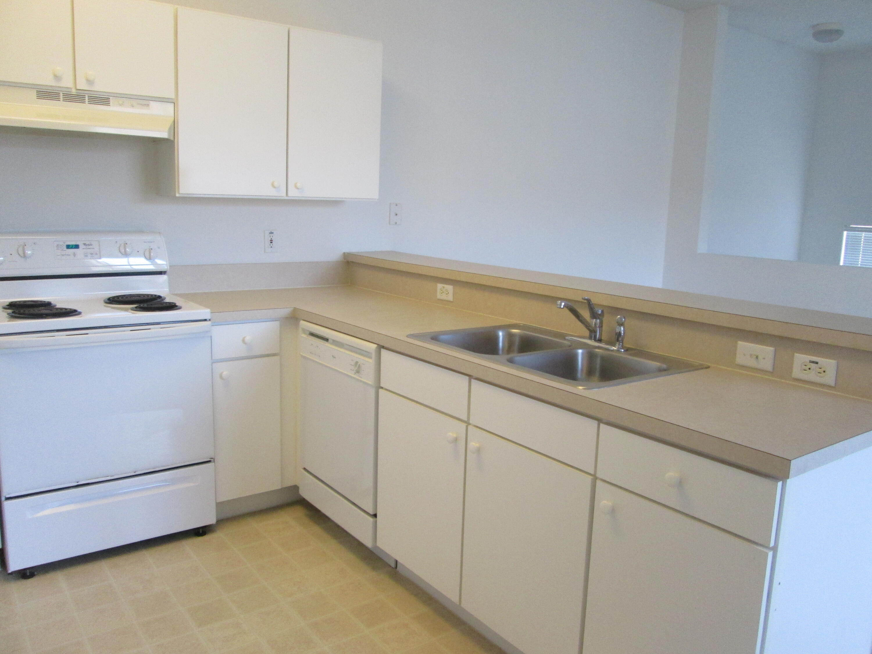 105 Lighthouse Circle, Unit J Tequesta, FL 33469 - Photo 9 of 18 a kitchen with a sink and cabinets