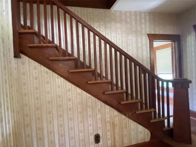a view of staircase with railing and white walls