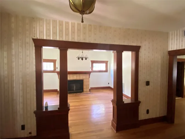 a view of a hallway with wooden floor and staircase