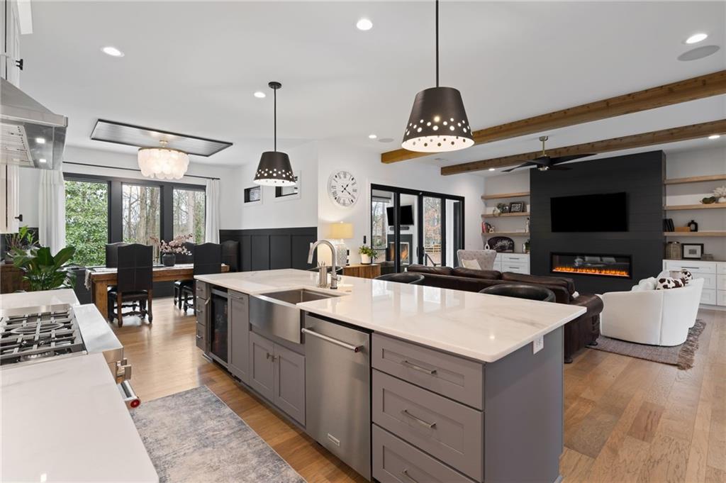 4226 South Berkeley Lake Road Northwest Berkeley Lake, GA 30096 - Photo 18 of 61 a large kitchen with stainless steel appliances granite countertop a stove a sink dishwasher a dining table and chairs with the view of living room