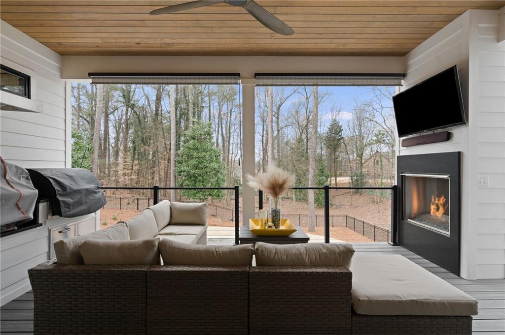 4226 South Berkeley Lake Road Northwest Berkeley Lake, GA 30096 - Photo 22 of 61 a living room with couch a flat screen tv and a floor to ceiling window