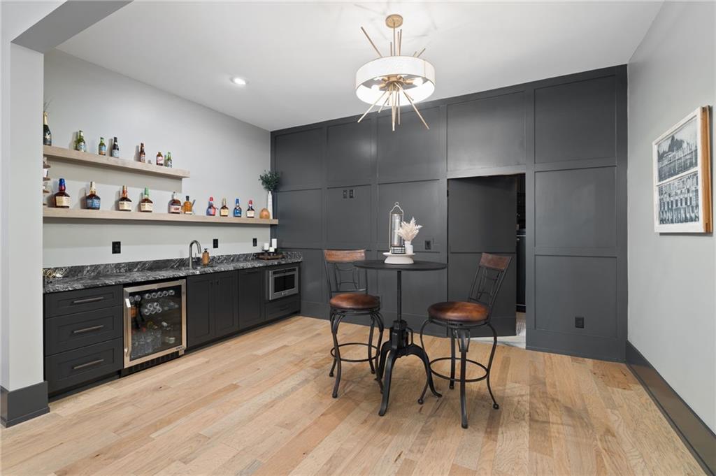 4226 South Berkeley Lake Road Northwest Berkeley Lake, GA 30096 - Photo 28 of 61 a kitchen with stainless steel appliances granite countertop a stove top oven a sink dishwasher and a dining table with wooden floor