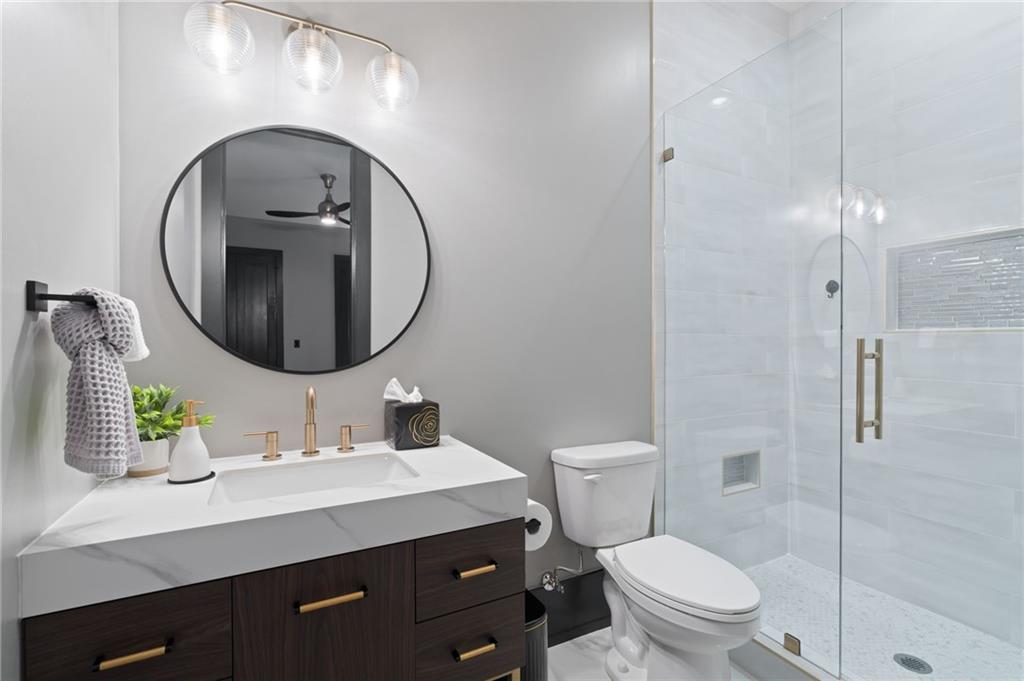 4226 South Berkeley Lake Road Northwest Berkeley Lake, GA 30096 - Photo 30 of 61 a bathroom with a toilet a sink and mirror