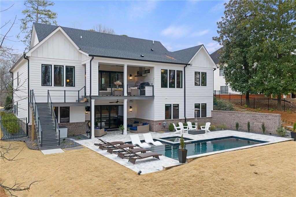 4226 South Berkeley Lake Road Northwest Berkeley Lake, GA 30096 - Photo 38 of 61 a view of a white house with couches table and chairs