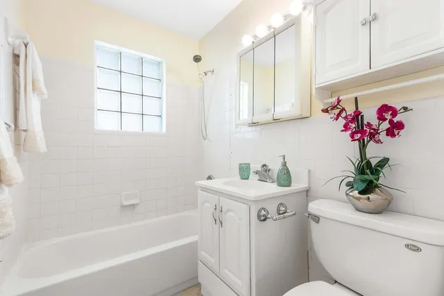 a bath room with a toilet a sink and a bathtub