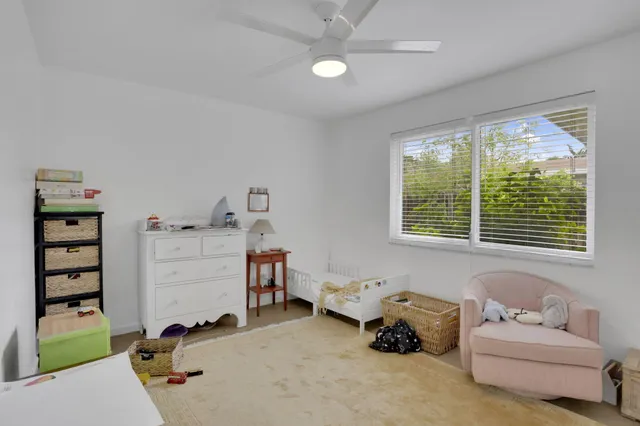 a room with furniture a air conditioner vent and a window