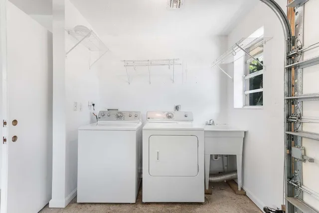 a utility room with cabinets washer and dryer