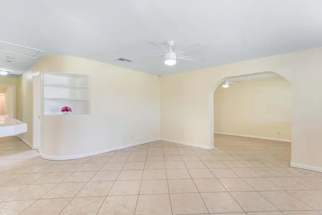 en empty room with white walls and fan