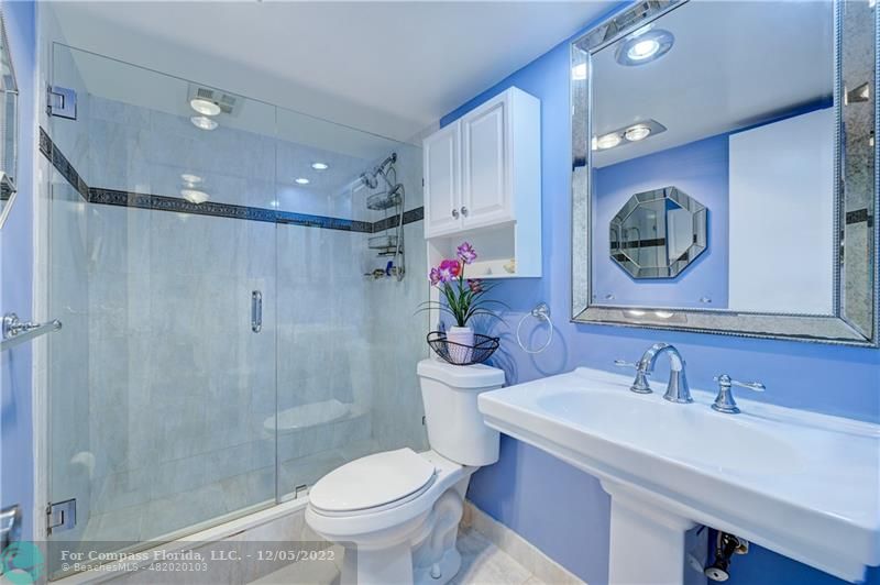 a bathroom with a sink vanity mirror and toilet