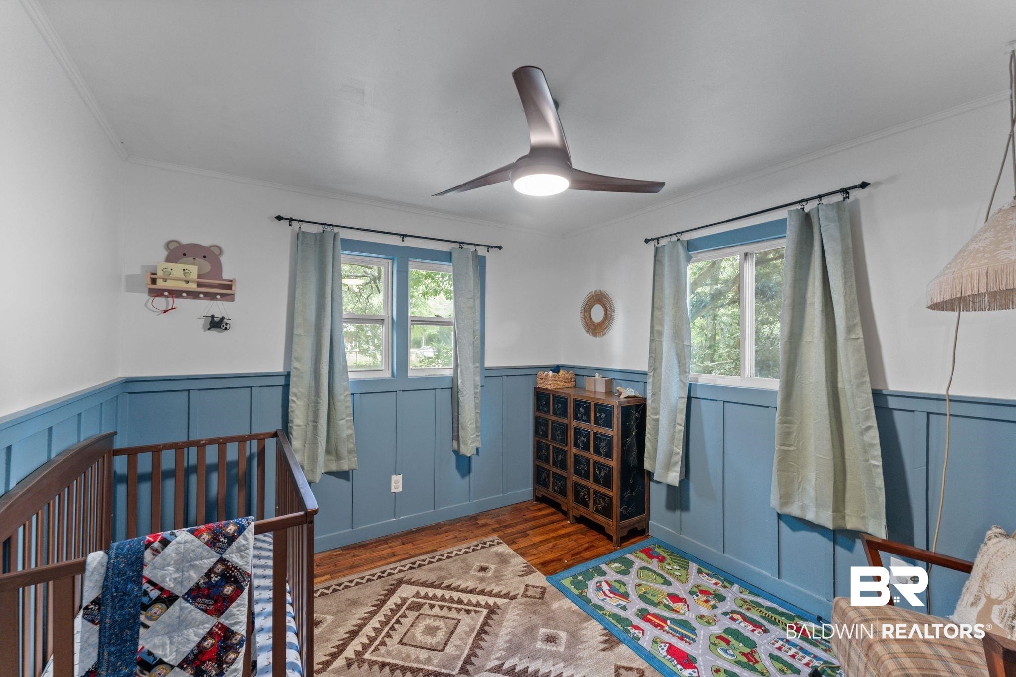 10785 Gregg Road Semmes, AL 36575 - Photo 19 of 35 Bedroom featuring wood finished floors, wainscoting, crown molding, a ceiling fan, and a crib