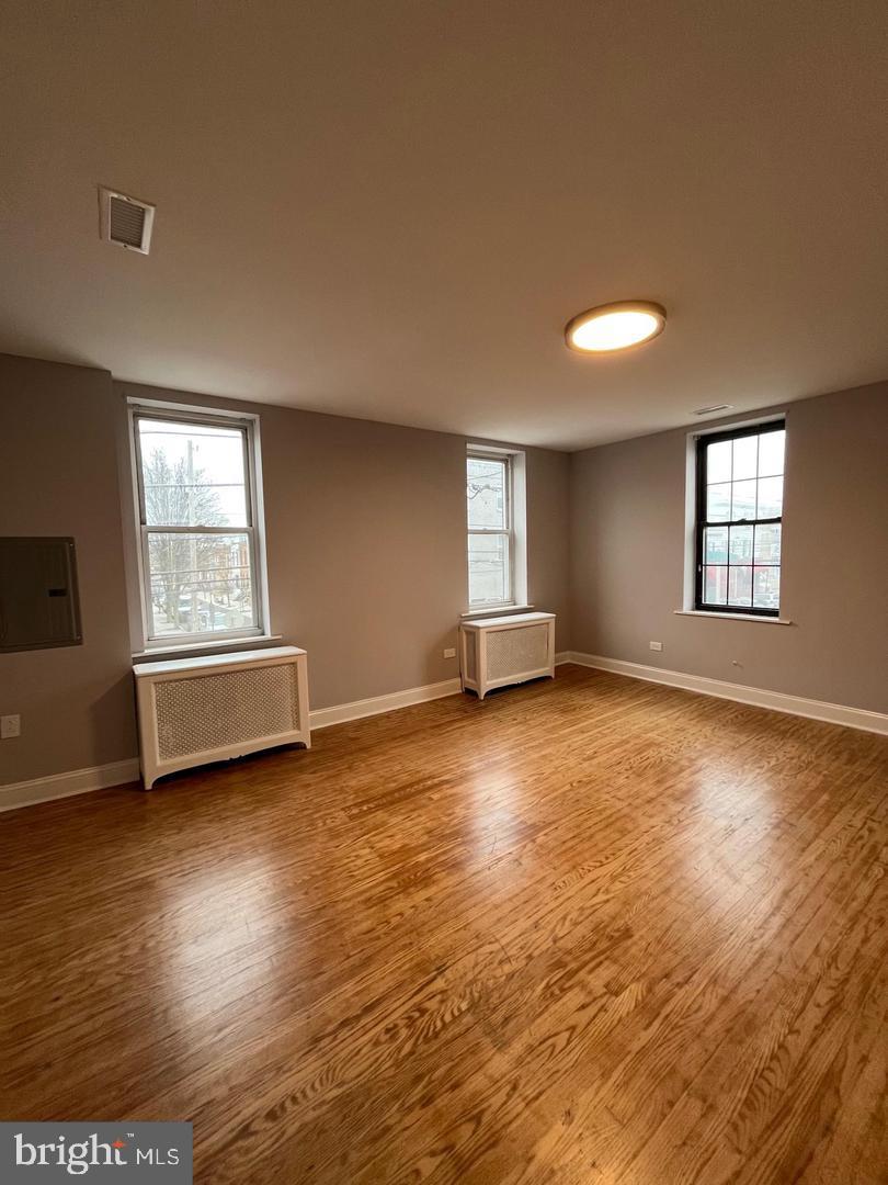 1208 Mifflin Street, Unit 2 Philadelphia, PA 19148 - Photo 5 of 14 a view of empty room with wooden floor and fan
