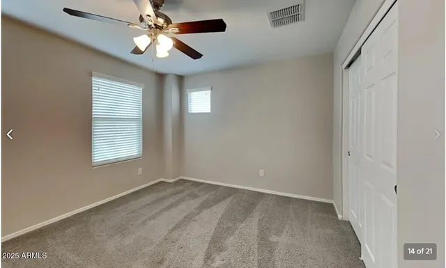 an empty room with a window and a fan