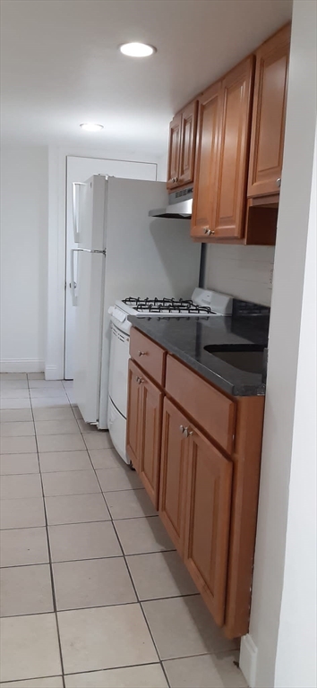 104 Beacon Street, Unit 1 Chelsea, MA 02150 - Photo 11 of 12 a kitchen with stainless steel appliances granite countertop a stove and a refrigerator
