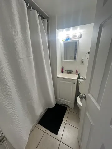 a bathroom with a sink a toilet a mirror and shower