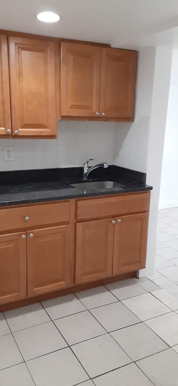 104 Beacon Street, Unit 1 Chelsea, MA 02150 - Photo 4 of 12 a kitchen with granite countertop cabinets and white appliances