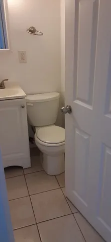 a white toilet sitting next to a white sink and vanity